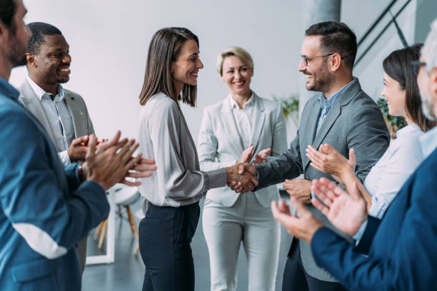 Business people shaking hands in the office. Business persons handshaking during a meeting in modern office.